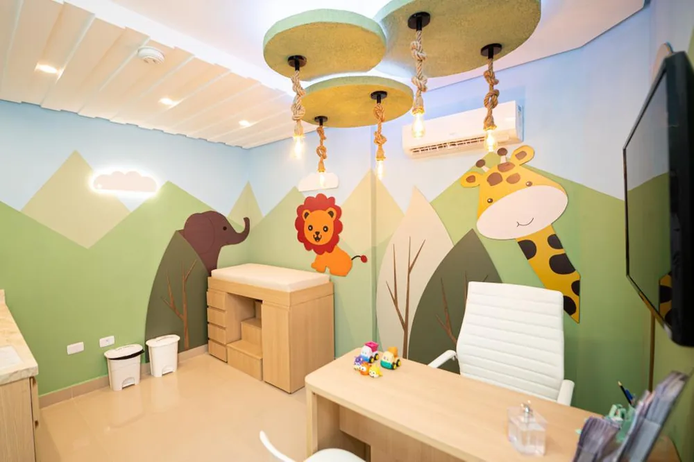 Sala de vacinação temática de safári com leão, elefante e girafa nas paredes