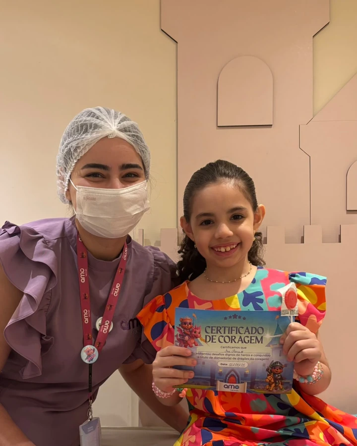 Menina sorrindo com a enfermeira na sala temática da Amo Vacinas